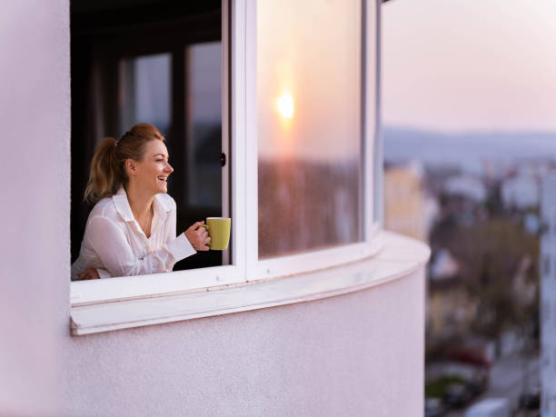istock Happy woman enjoying during coffee time on a window. 1249978183