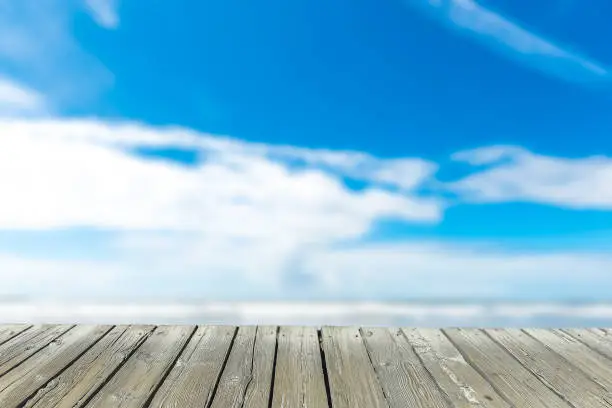 empty wooden deck table top Ready for product display montage with sea,blue sky and beach background..