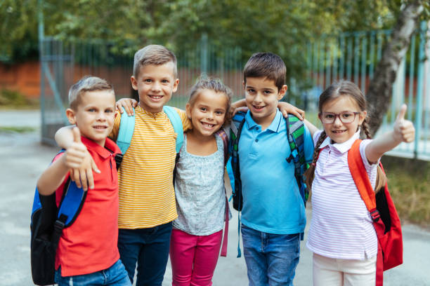 istock Beautiful embraced children standing at schoolyard 1249979354