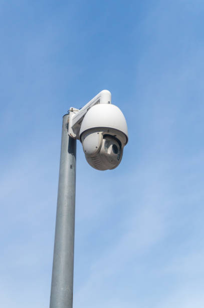 überwachungskamera oder p/t/z-kamera in der stadt mit dem hintergrund des himmels - vertical security camera security system security stock-fotos und bilder