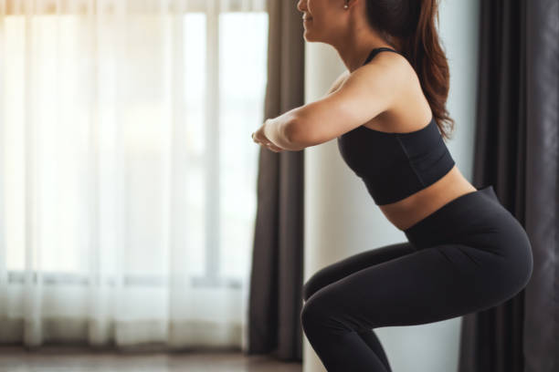 istock a beautiful young asian woman doing squats , workout at home 1249985876
