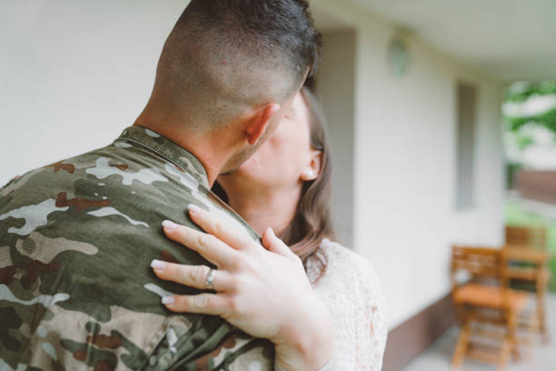 istock Woman kissing her husband in army uniform 1249985992
