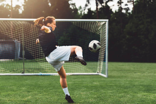 Female soccer player shooting on the goal Young female soccer player training on a football field. Young woman practicing her skills, trying to become a professional athlete. high school soccer stock pictures, royalty-free photos & images
