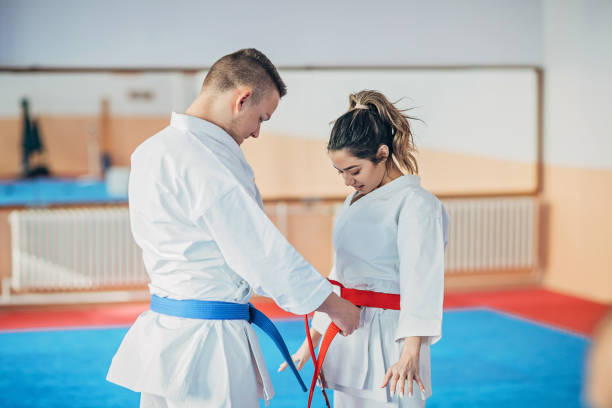 istock Young karate trainer tying belt for his student 1249988390