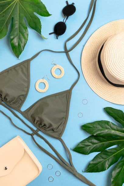 istock Vacation flat lay composition. Green leaves, straw hat, handbag, women's accessories on blue background. 1249988878