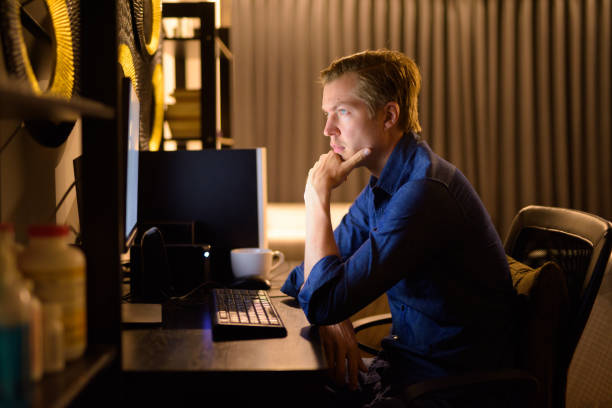 istock Young handsome businessman thinking while working overtime at home late at night 1249989197