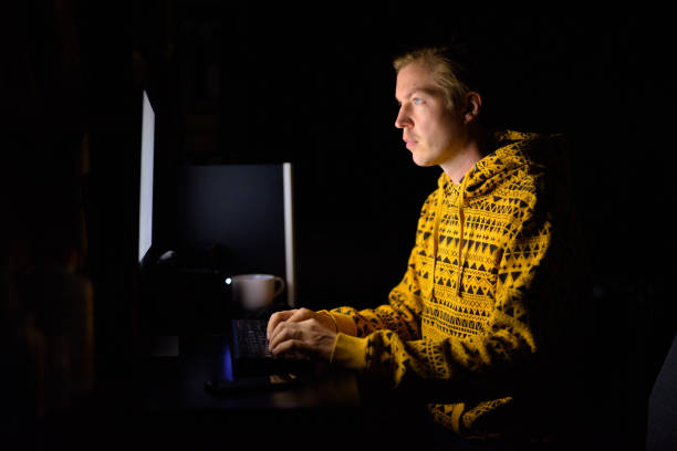 istock Young handsome man working overtime at home in the dark 1249989778