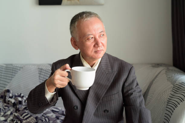 istock Mature Japanese businessman thinking while drinking coffee at home 1249991356