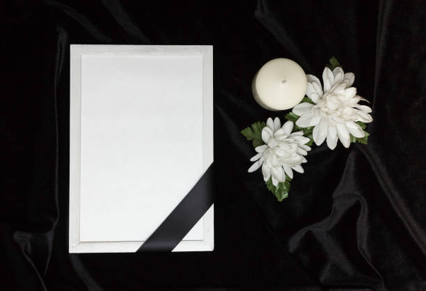 Condolence card. Memorial frame with black ribbon. White flowers and a burning candle. Black background. Condolence card. Memorial frame with black ribbon. White flowers and a burning candle. Black background. funeral parlor photos stock pictures, royalty-free photos & images