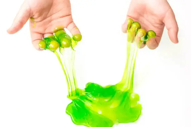 Toy called Slime. Mucus in children hand on a white background. Selective focus.