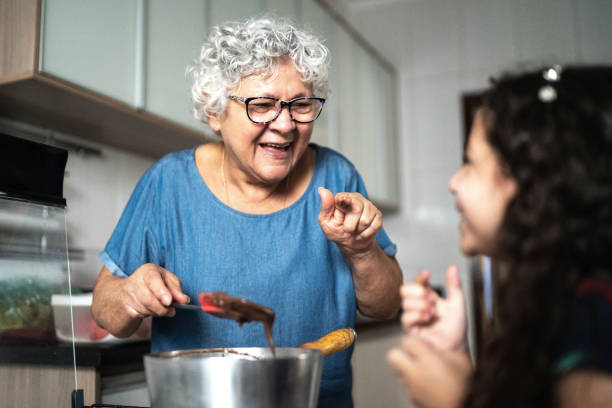 großmutter macht schokolade mit enkelin zu hause - grandmother cooking baking family stock-fotos und bilder