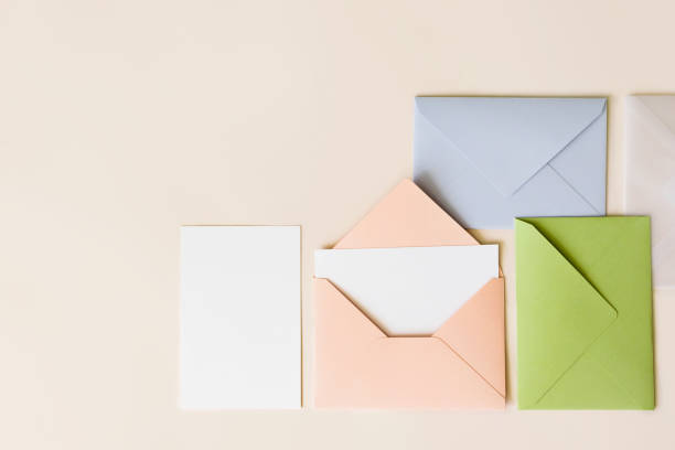 istock Mockup blank letter inside pink envelope, empty white paper and colorful closed envelopes on beige background, top view. Greeting card concept with copy space. Universally invitation template 1250000576