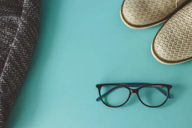 Fatlay view with glasses, shoes on blue background. With copy space
