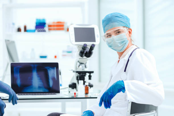 istock female doctor in a protective mask sitting at a laboratory table 1250002165