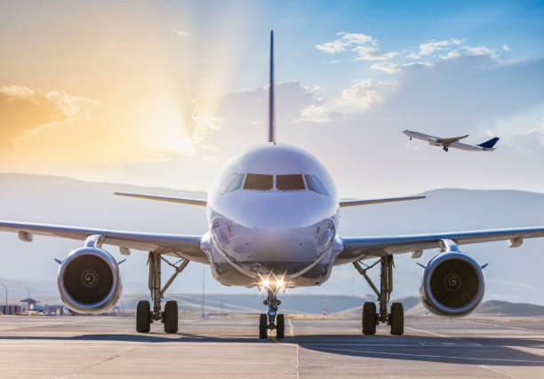 離陸前の滑走路上の旅客機の正面図 - landing sunset airplane flying ストックフォトと画像