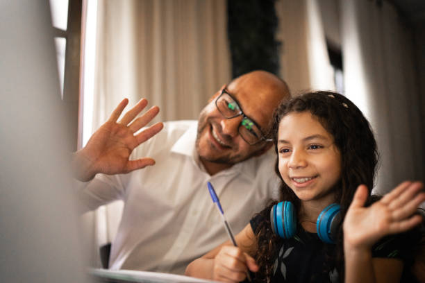 istock Father helping daughter with her homework on video chat / e-learning at home 1250004156