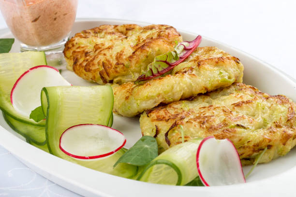 istock Zucchini pancakes with sauce on a white plate 1250004251