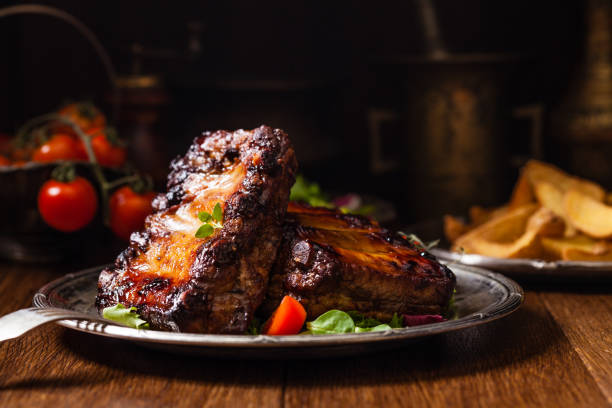 istock Roasted ribs, served on an old plate. Dark or balck background. 1250004262