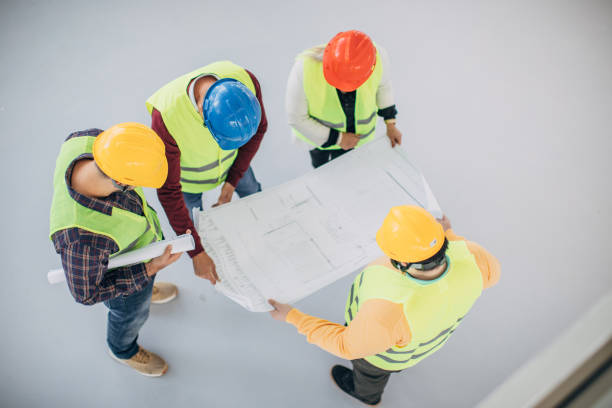 istock Engineers and architects looking at building blueprint at the construction site 1250005128