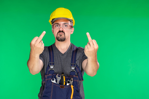Close-up of mechanic showing thumbs down sign on green background.  The scene is situated in controlled studio environment in front of green background. Photo is taken with SONY AIII camera
