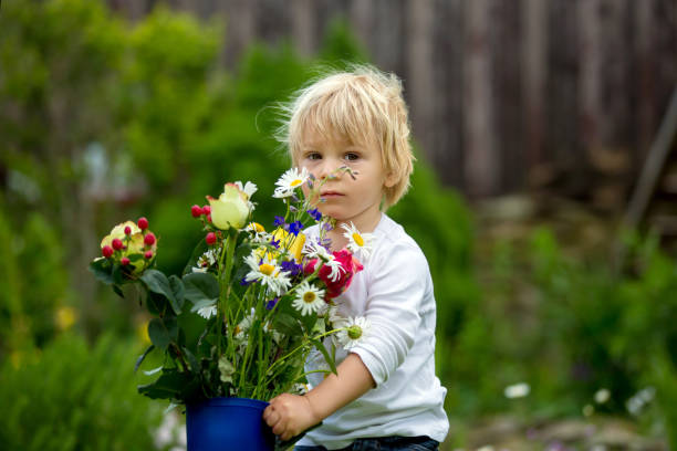 istock Child holding rubber boots with beautiful flowers 1250010164