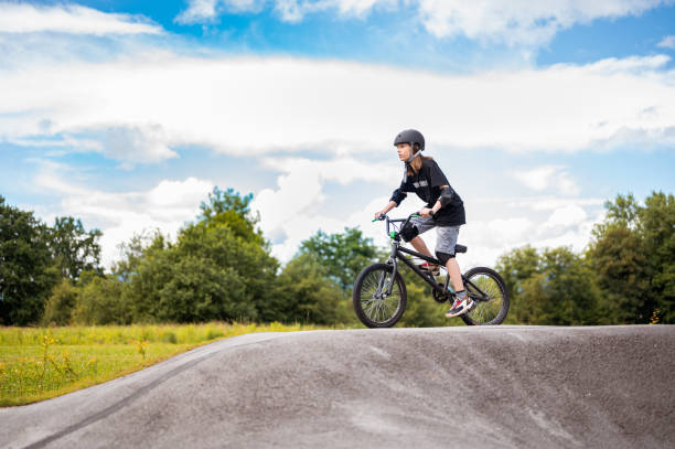 junges mädchen reitet bmx fahrrad - bmx stock-fotos und bilder