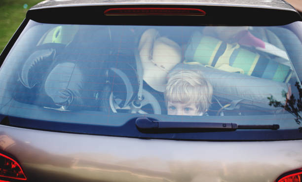 istock Small boy sitting in loaded car boot with closed door, local trip concept. 1250019295