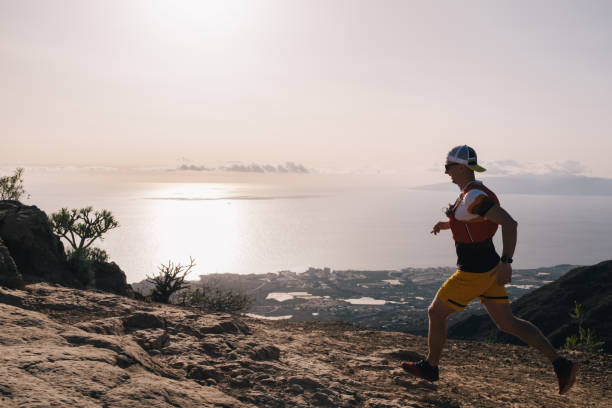 istock Manan runs cross country on a path in mountain path at Canary Island. Ocean view 1250020578