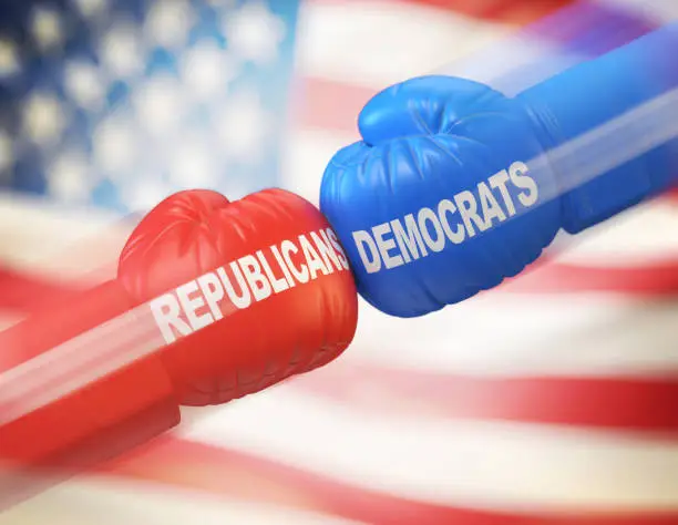 Photo of Democrats vs. Republicans. Two boxing gloves against each other in colors of Democratic and Republican party