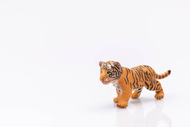 close up of a plastic baby tiger toy isolated on a white background