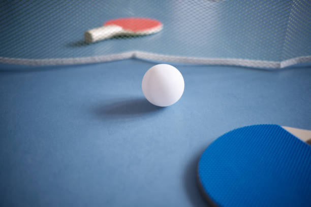 A mini game of table tennis with two bats and a ball.