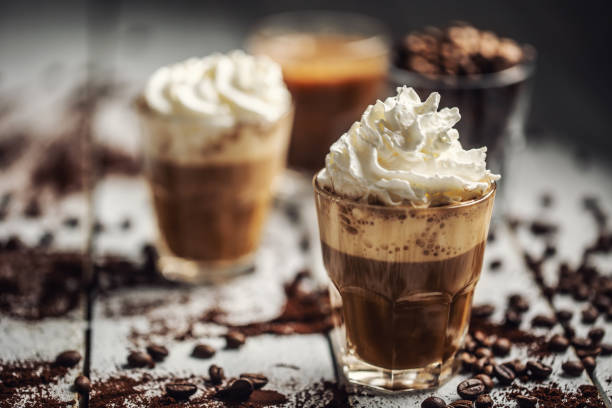 グラスカップにホイップクリームとこぼれたコーヒー豆とブラックコーヒー - モカ ストックフォトと画像
