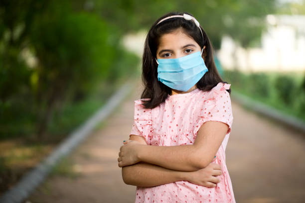 Little girl with protective face mask at park