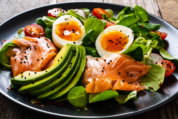 istock Smoked salmon with boiled eggs, avocado and vegetables on wooden table 1250026807