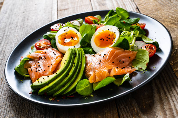 istock Smoked salmon with boiled eggs, avocado and vegetables on wooden table 1250026860