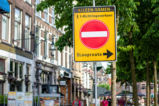 Social distancing in the city centre. One way trail sign during coronavirus outbreak, to alert people for one-way traffic, that says: \
