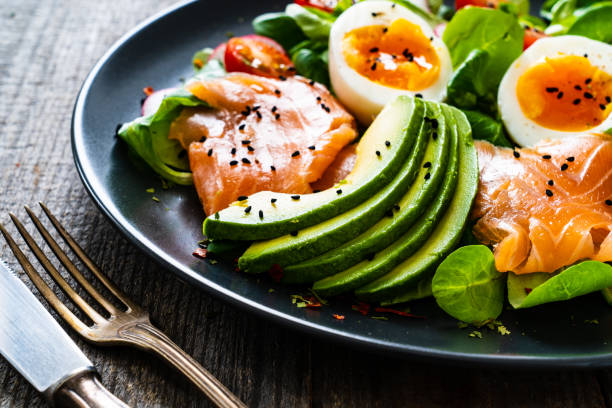 istock Smoked salmon with boiled eggs, avocado and vegetables on wooden table 1250026963