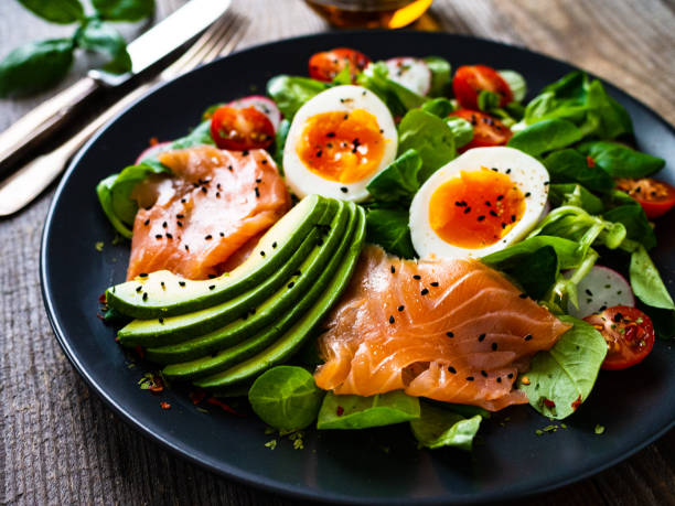 istock Smoked salmon with boiled eggs, avocado and vegetables on wooden table 1250027000