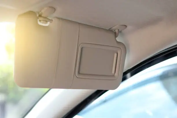 Photo of Sun visors prevent sunlight shining into the eyes while driving. Sun visors in the area in front of the car above.