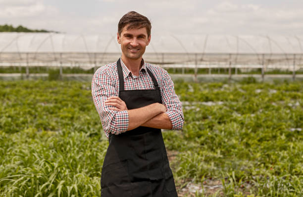 istock Confident farmer standing near field 1250032100