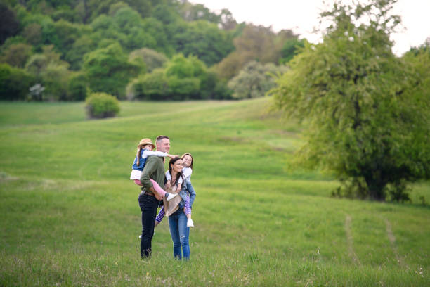 istock Happy family with two small daughters standing outdoors in spring nature. 1250032212