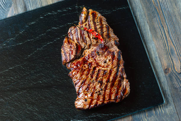 istock Grilled ribeye beef steak on black stone. 1250032793