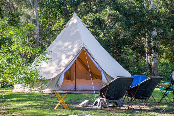 キャンプ場でのグランピングキャンプティーピーテントと椅子 - テント 写真 ストックフォトと画像
