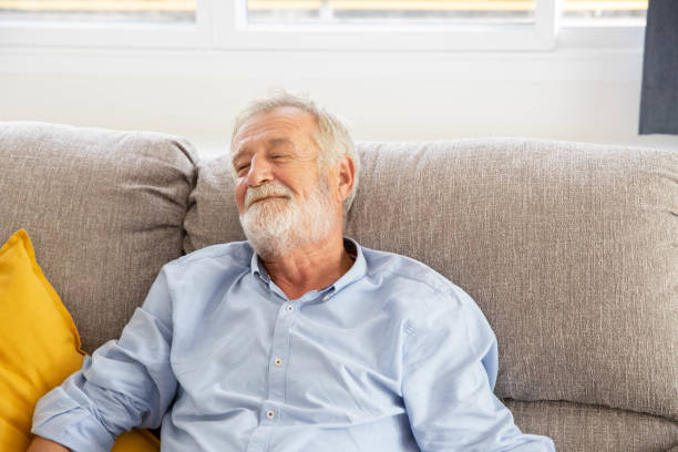 istock Happy senior retirement old man smiling while sitting at the sofa in his home 1250035128