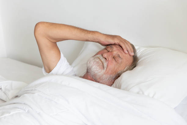 istock Worried senior retirement man lying awake in his bed 1250035270