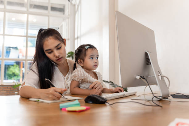 istock Work from home concept. Mother and daughter using a computer and internet during mother working from home 1250035435
