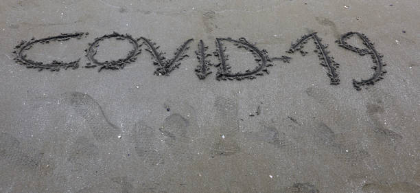 istock Text Covid-19 on the sand of the beach 1250036394