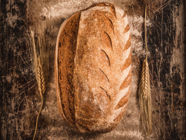 istock Rustic crusty loaf of bread on rustic background. 1250041431