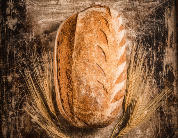 Bakery gold rustic crusty loaf of bread on rustic background.