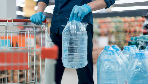 istock man in protective gloves with a bottle of drinking water 1250041485